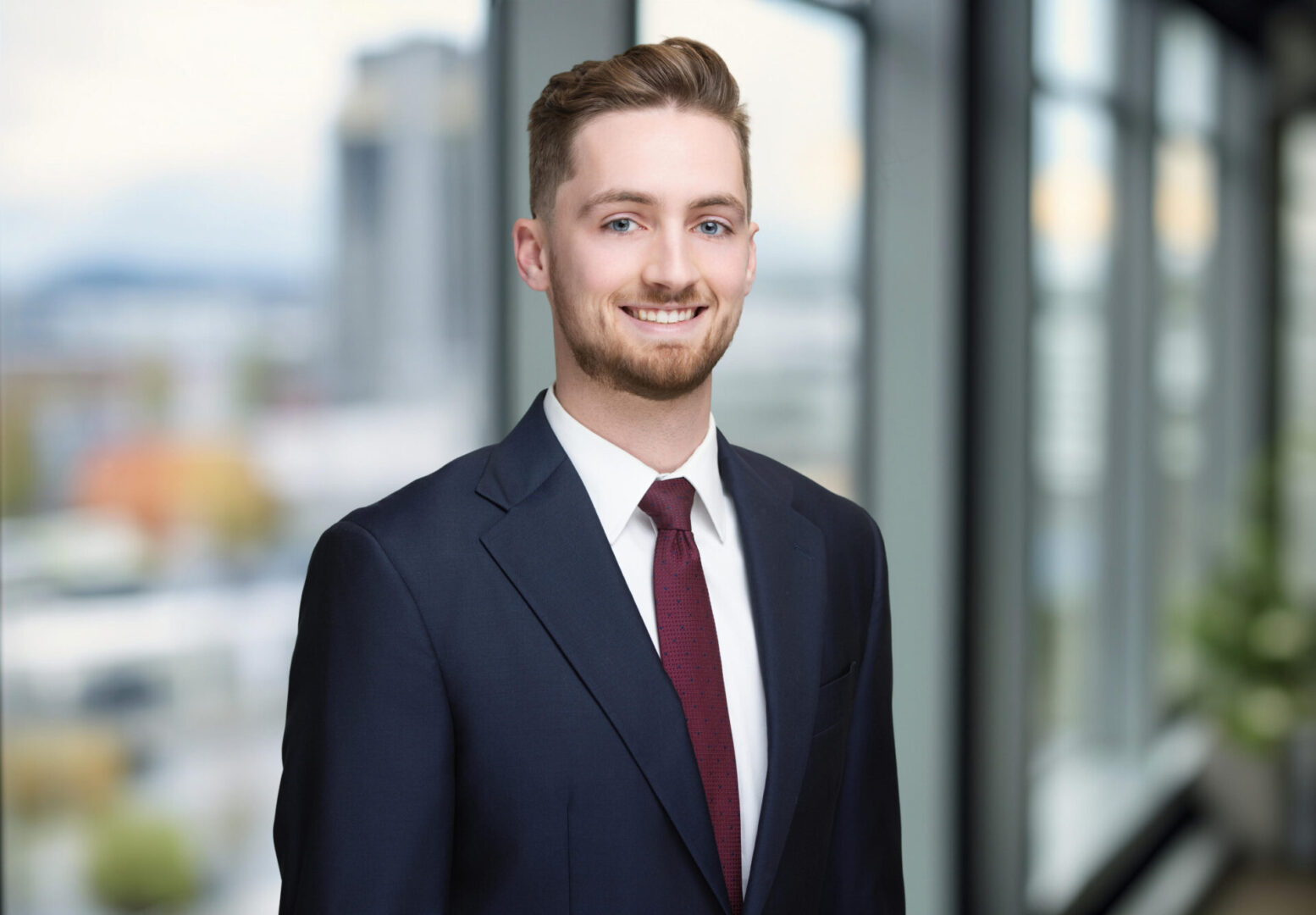 Professional young man in a suit smiling confidently.
